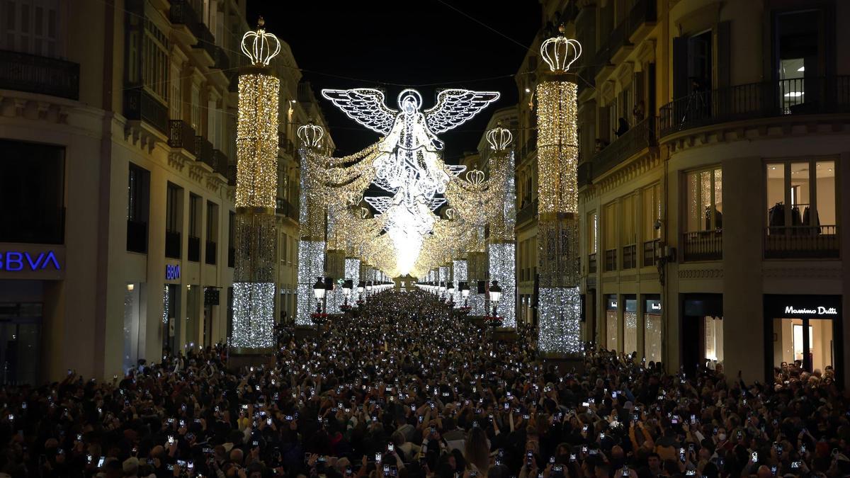 Ciudadanos toman fotos en la inauguración del alumbrado de Navidad de Málaga en 2022