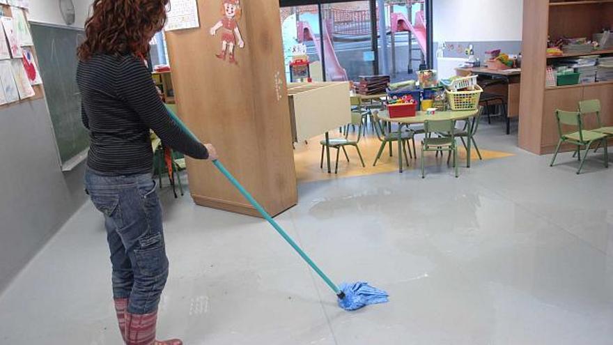 Una trabajadora municipal limpia, ayer, un aula de Infantil. / fran martínez