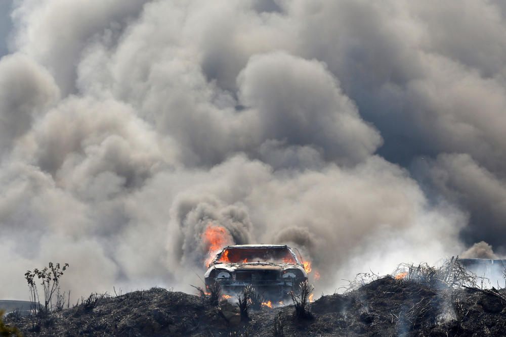 Smoke billows from burning cars during a fire at ...