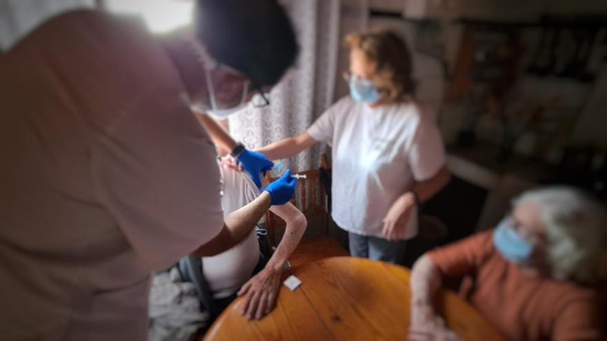 Un sanitario administra una vacuna a domicilio.
