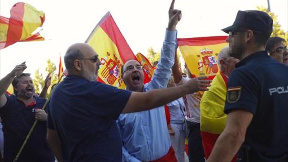 Un grupo de personas increpan a los asistentes a la asamblea convocada por Unidos Podemos.