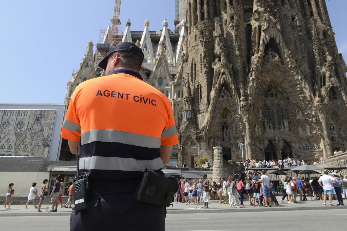 Un agente cívico, frente a la Sagrada Família.