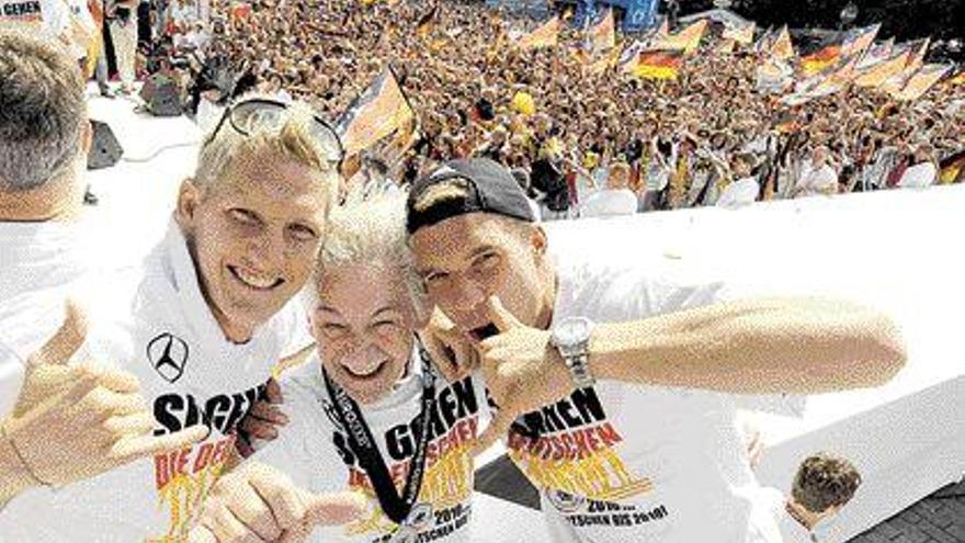 Lukas Podolski (dcha) y Bastian Schweinsteiger (izda) y el fisioterapeúta Adolf Katzenmeier. /Gero Breloer