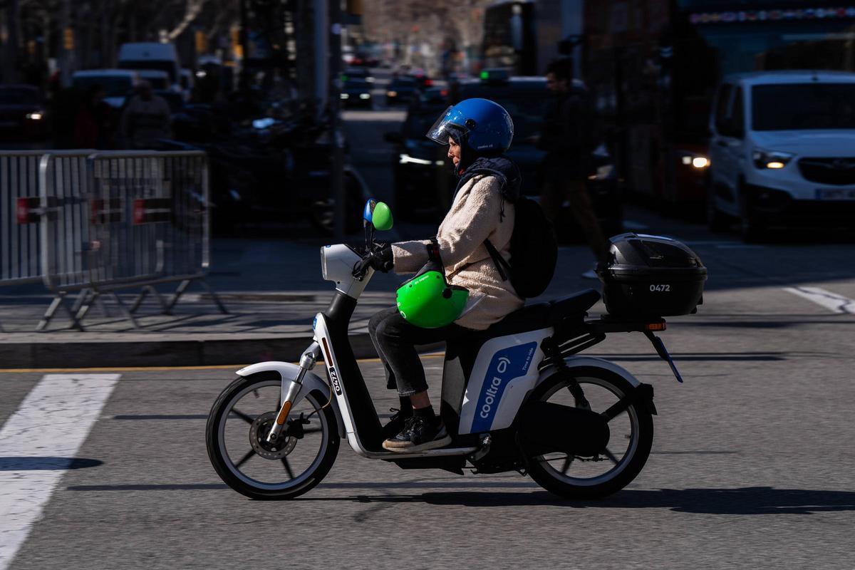 Una moto de Cooltra circula por el paseo de Gràcia, este martes