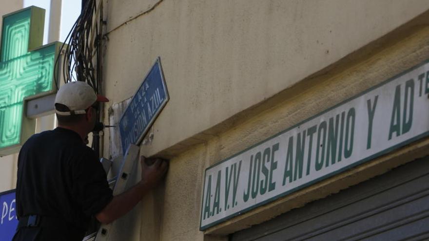 Un operario repone la placa de la División Azul tras la suspensión cautelar ordenada por la juez