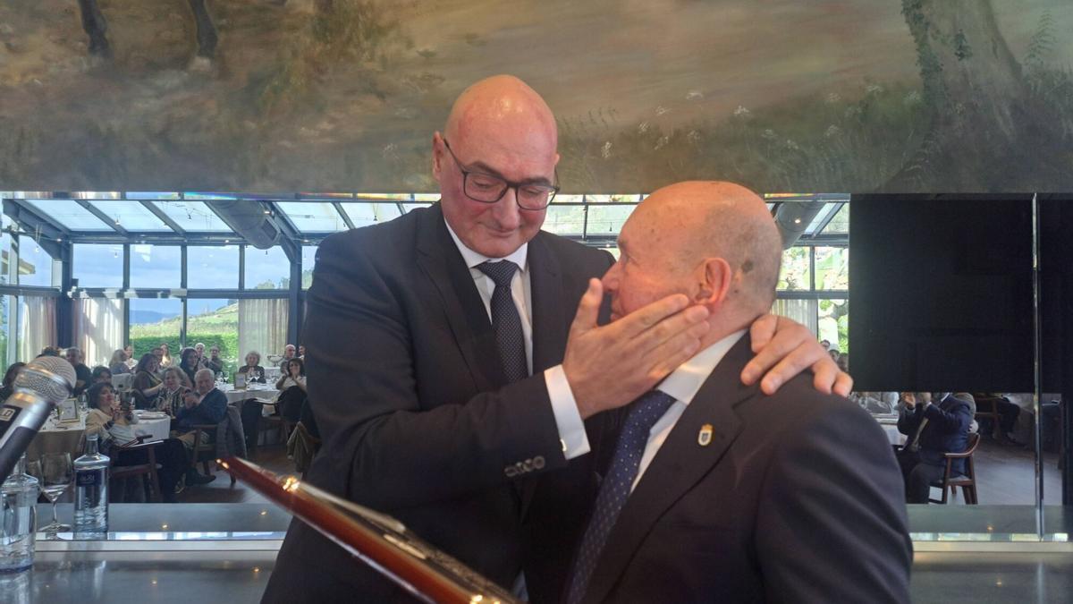 Heriberto Fernández, "Caco", entrega una placa a Pepe Rionda, al que sustituye como presidente del Base Oviedo