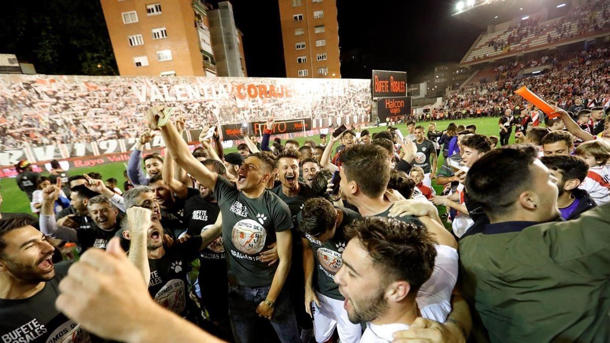 Jugadores y aficionados del Rayo celebran el ascenso a Primera en Vallecas el pasado mayo