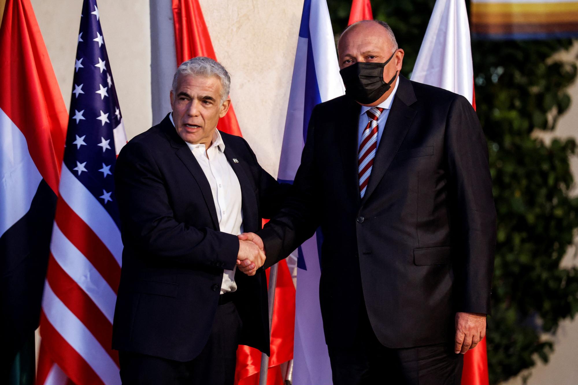 El ministro de Exteriores de Israel Yair Lapid saluda a su homólogo egipcio Sameh Shoukry, en la Cumbre del Néguev, este domingo, en Israel.