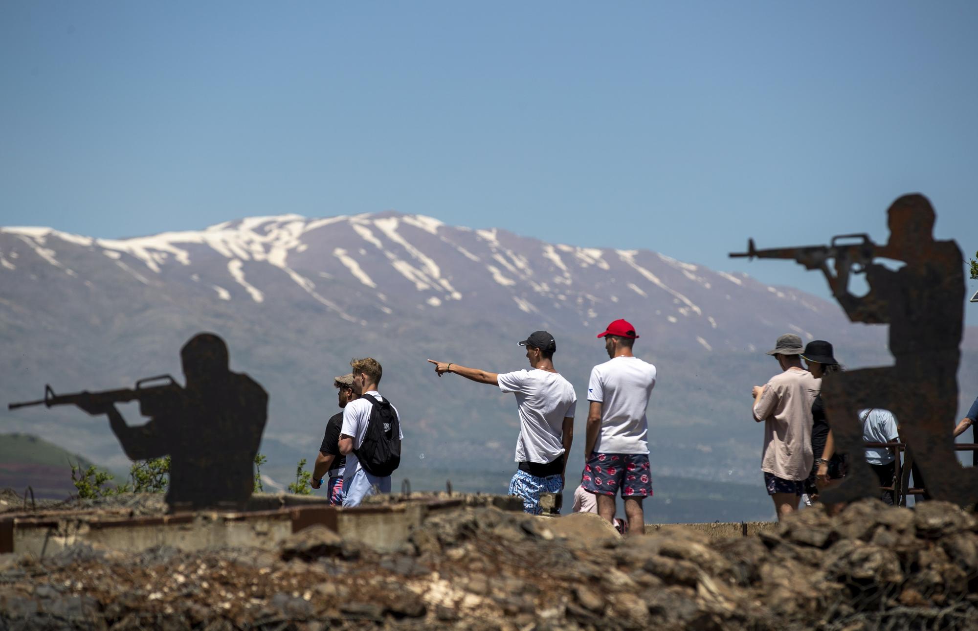 Turistas israelís junto a las estatuas de dos soldados en el territorio ocupado de los Altos del Golán