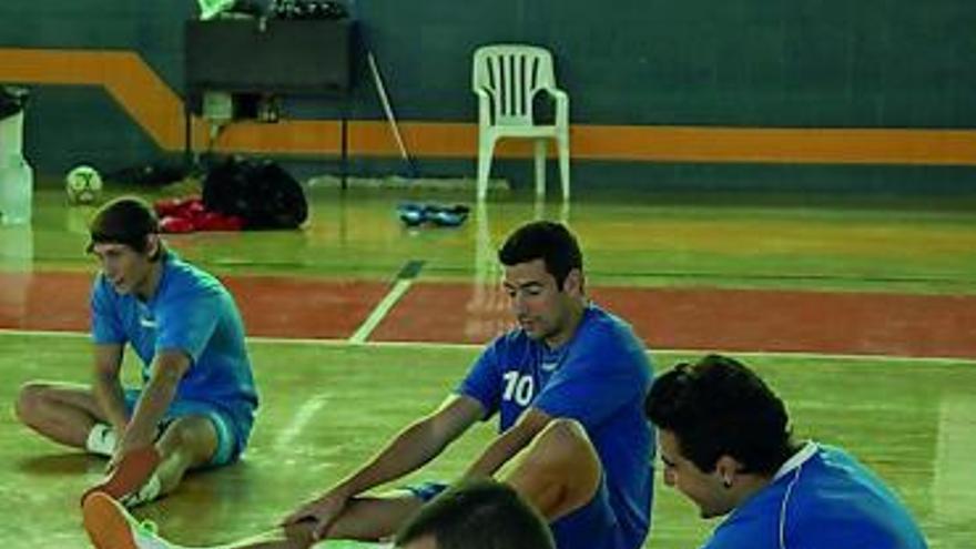 Los jugadores estiran tras un entrenamiento.