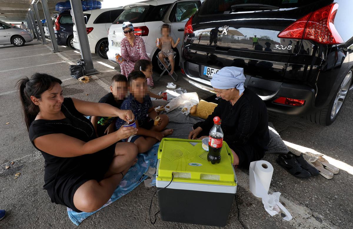 Una familia prepara el almuerzo en el aparcamiento.