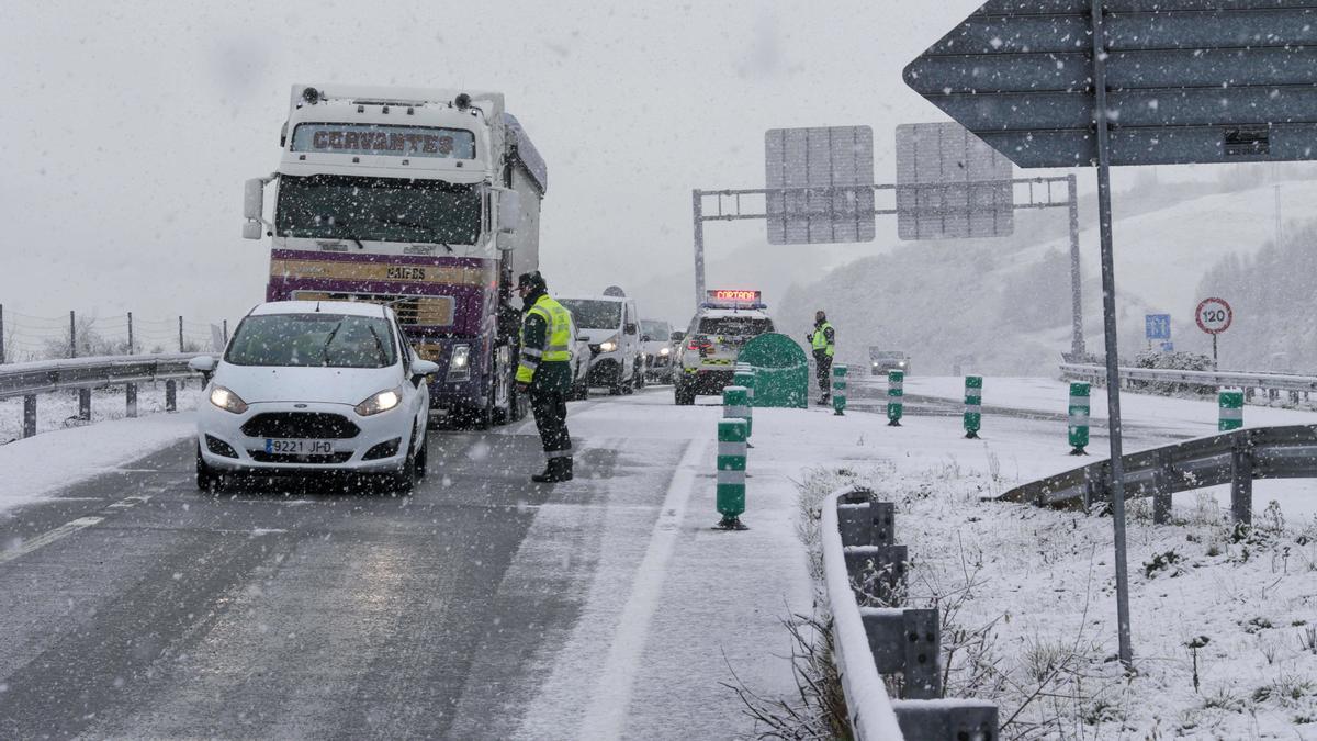 La Guardia Civil regula el tráfico en el punto de la autovía A-6 donde hoy se ha cortado la circulación por las nevadas.