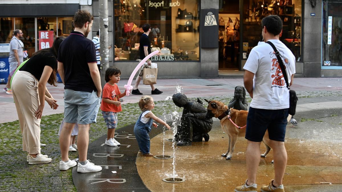 Unos niños se refrescan en una fuente en Pontevedra.