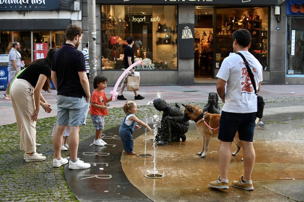 Unos niños se refrescan en una fuente en Pontevedra.