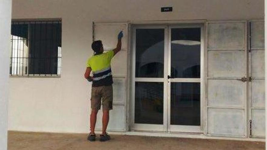 Un operario del Consell pinta la puerta de un aula del colegio de Sant Ferran.
