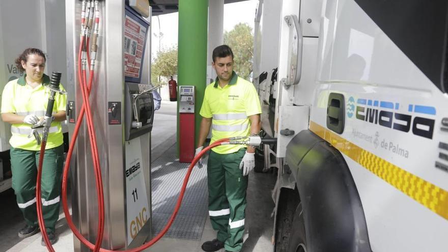 Dos operarios de Emaya repostan gas en un camión de recogida de residuos.