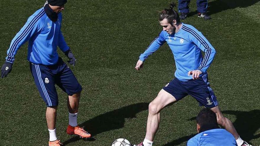 Gareth Bale controla el balón justo delante de Cristiano Ronaldo.