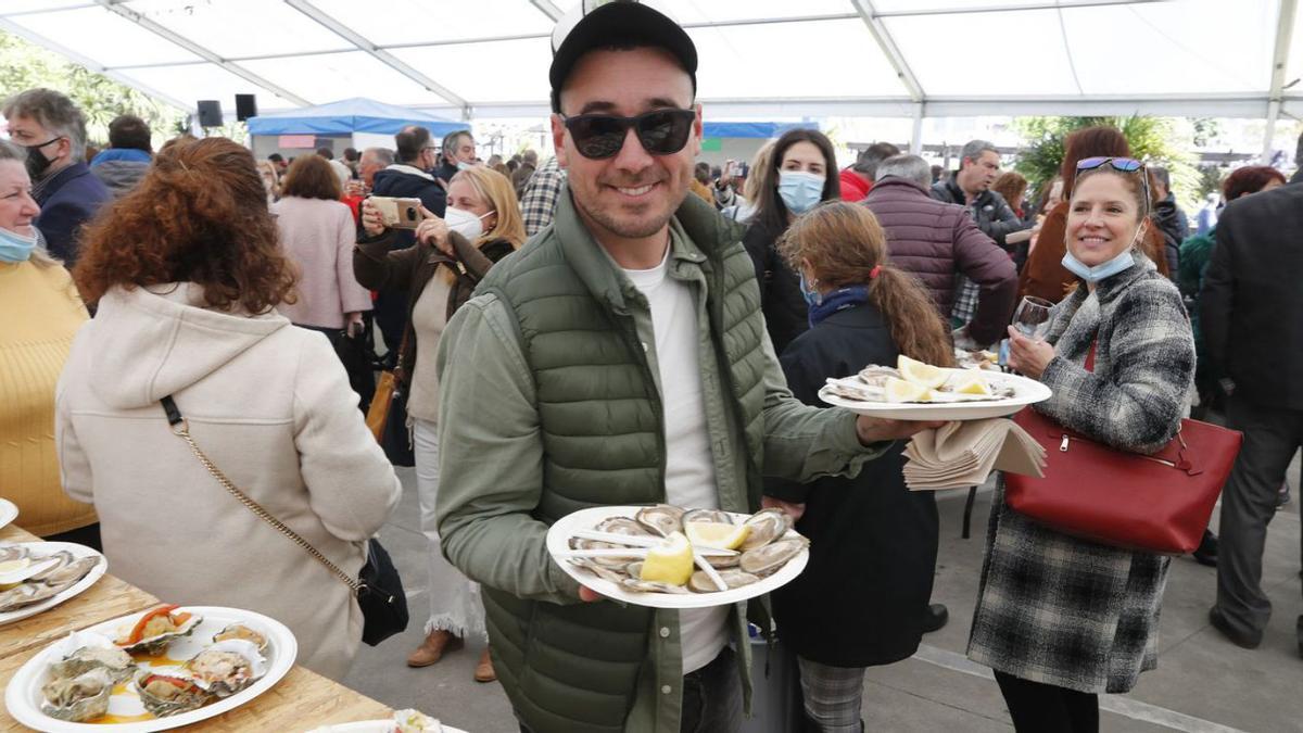 Un comensal con sus raciones de ostras al natural, ayer, en la multitudinaria Festa da Ostra.