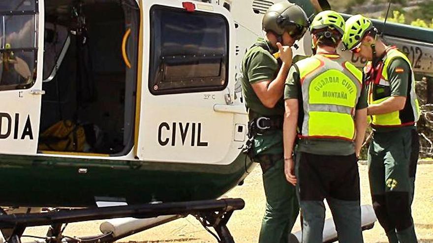 Guardias civiles, junto a su helicóptero. | GUARDIA CIVIL