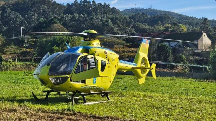 El helicóptero medicalizado, ayer, junto a la finca de Reboreda en la que se produjo el accidente.