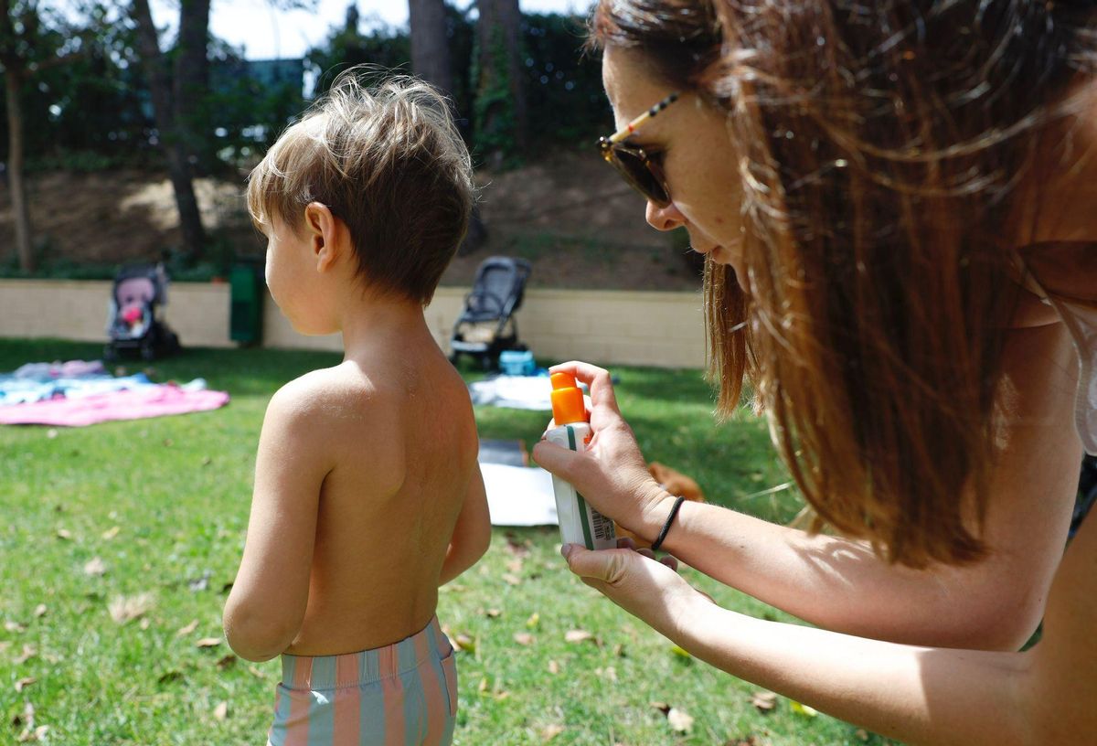 Una madre le echa crema de sol a su hijo en las piscinas de Salduba, Zaragoza, este sábado.