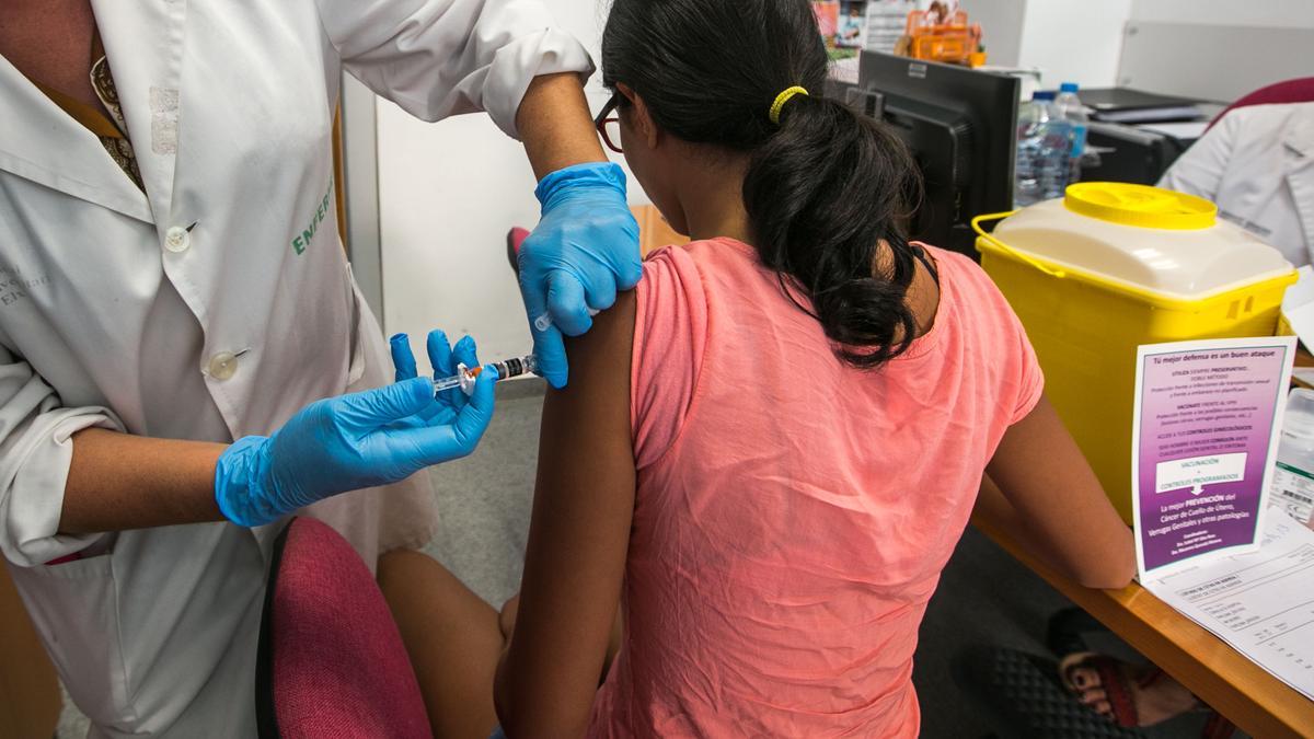 Una enfermera administra la vacuna del papiloma a una niña, en imagen de archivo