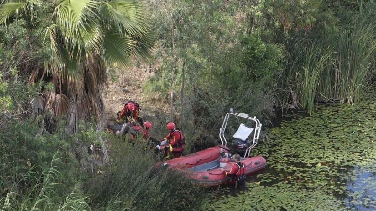 Los bomberos en la conocida como isla de los conejos tras rescatar al varón que se ha precipitado desde el puente Real.