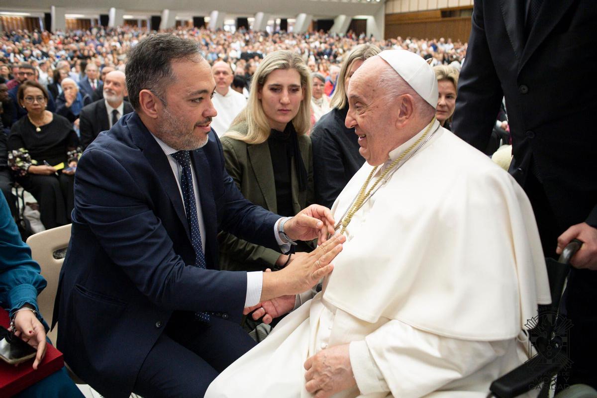 El hermano mayor del Amor, Álvaro Guardiola, impone al Papa una medalla de oro de la cofradía.