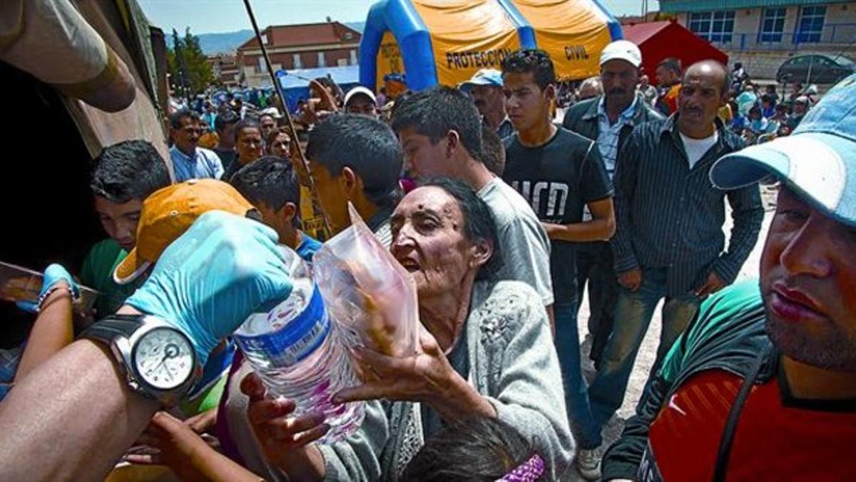 Alimentos 8 Miembros de Protección Civil reparten alimentos en un campamento de damnificados.