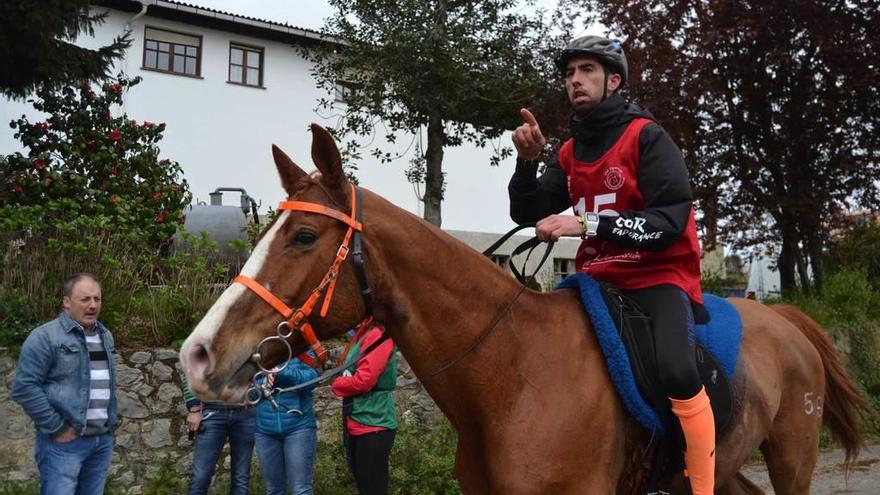 En la foto de arriba, varias personas refrescan a uno de los caballos para ayudarlo a bajar sus pulsaciones. Sobre estas líneas, uno de los jinetes, a su llegada a la meta de la primera fase en los 80 kilómetros.