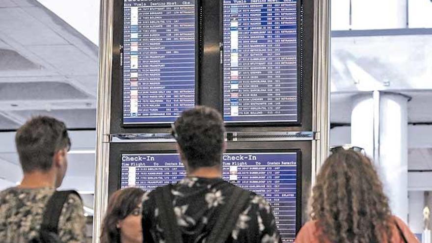 Pasajeros observan las pantallas informativas tras una jornada de anulación de vuelos.