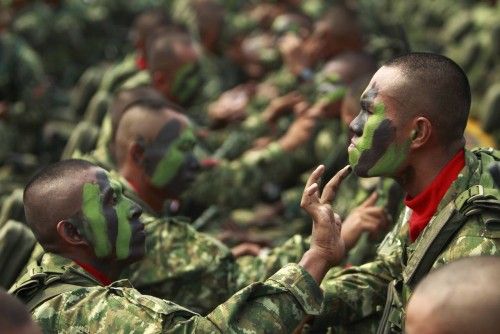 Soldados indonesios se ayudan entre ellos aplicándose las pinturas de camuflaje antes de la ceremonia que conmemora el 67 aniversario de la 'Indonesian National Military'.