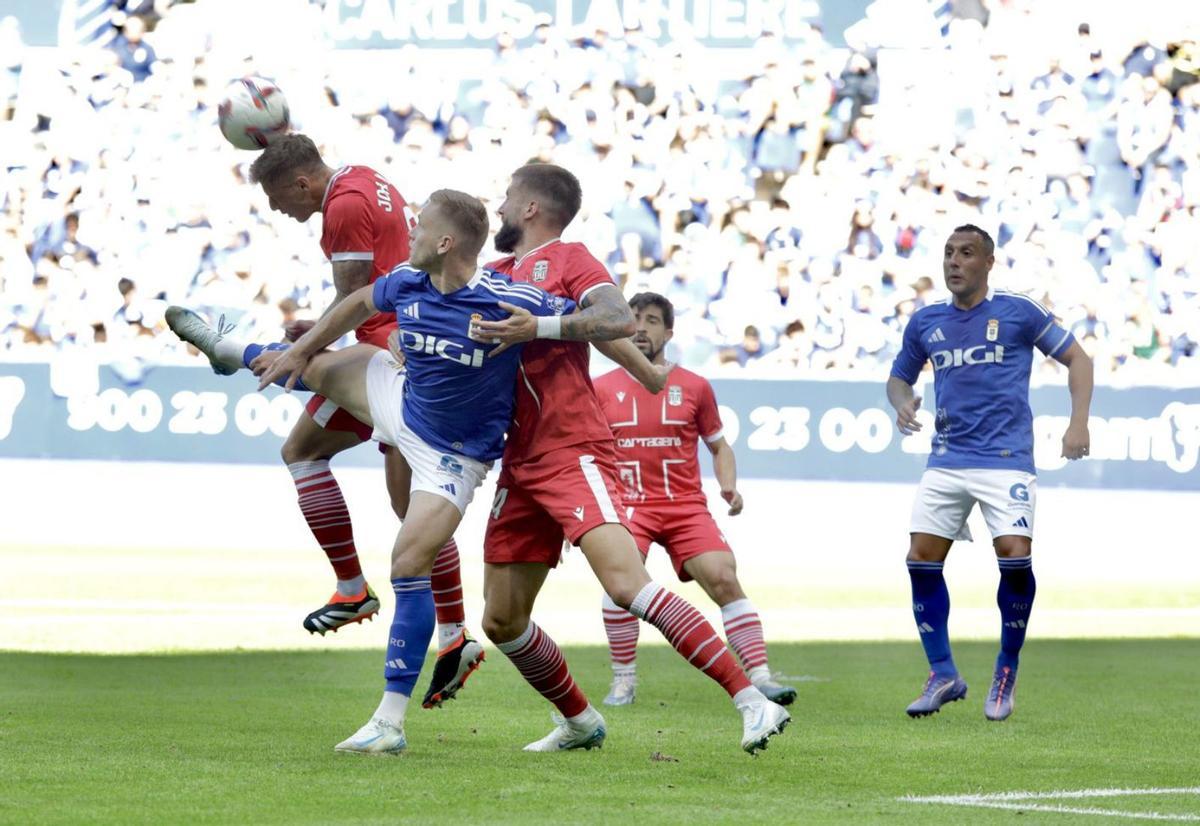 Jorge Moreno despeja un balón mientras Sipcic pelea con un delantero rival