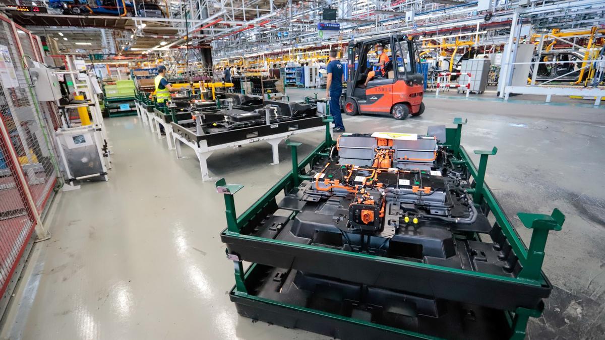 Varios operarios trabajando en una fábrica de vehículos.