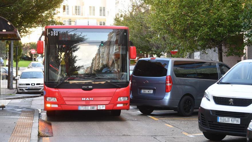 Un bus urbano pasa por un espacio muy estrecho en la avenida de Os Mallos por un turismo estacionado en batería. |   // VÍCTOR ECHAVE