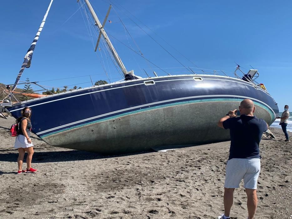 El velero Django quedaba varado en la playa de Benajarafe, el pasado viernes. A la espera de ser remolcado, el barco se ha convertido en una atracción para paseantes y bañistas, que fotografían la peculiar estampa.