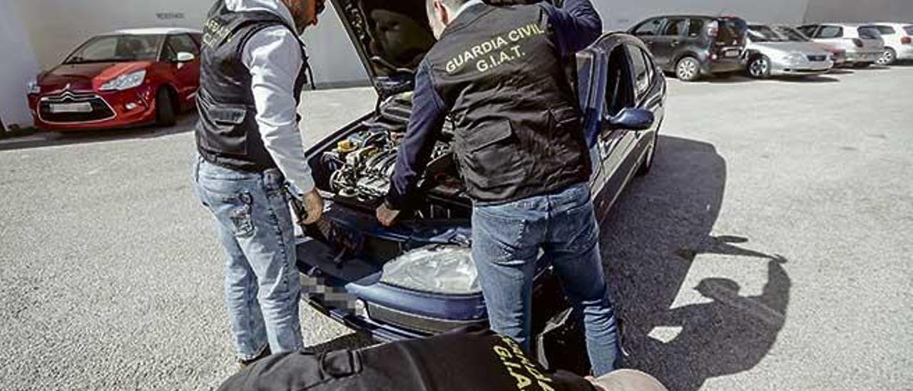 Dos miembros del GIAT examinan el motor de un vehículo intervenido.