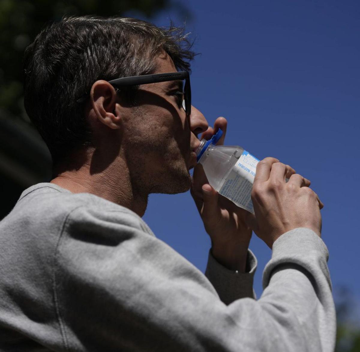 Un hombre se hidrata en la calle bebiendo agua. | Jose Luis Fernández