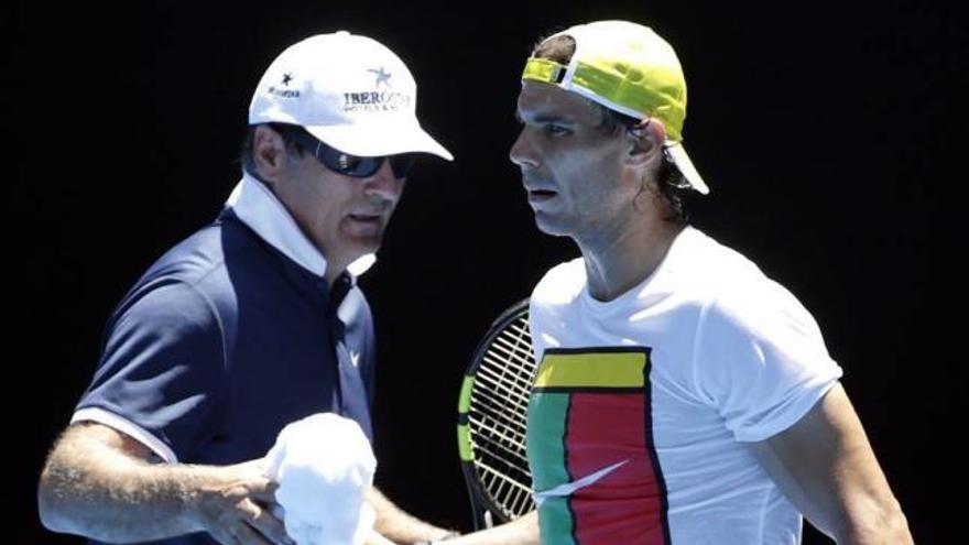 Toni Nadal le da una toalla a Rafel Nadal durante uno de los entrenamientos previos a su debut en el Gran Slam de Melbourne.