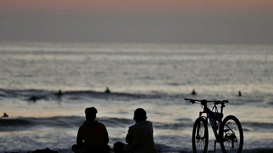 Bañistas ante una puesta de sol en la playa de Viña del Mar (Chile).