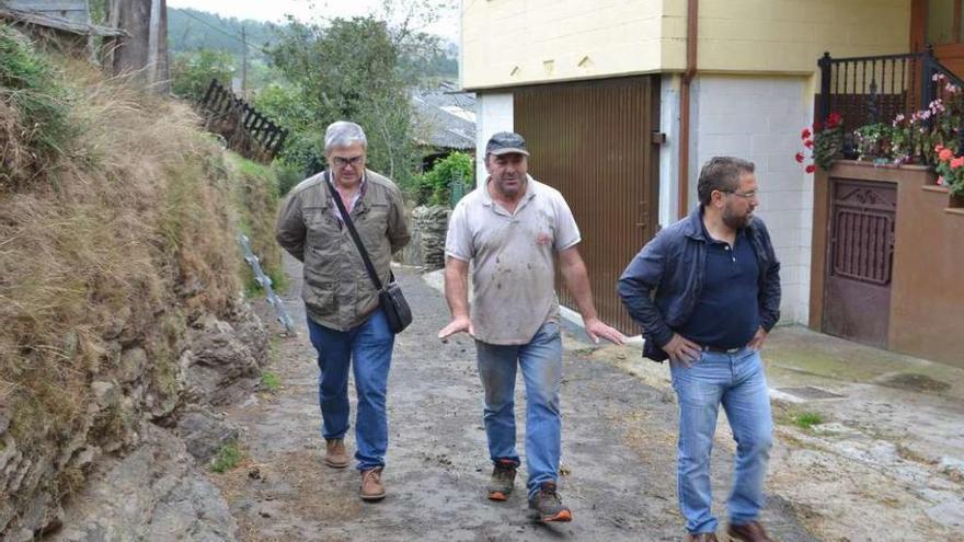 El técnico municipal, un vecino y Medela, ayer, durante su visita a la parroquia de Zobra.