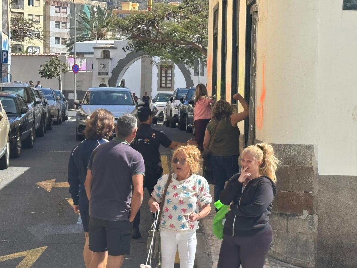Los vecinos exigen a los okupas que abandonen la casa de El Toscal en presencia de un policía nacional.