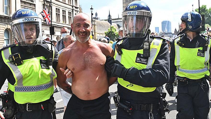 Un detenido, ayer en Londres, durante una manifestación contra las restricciones.   | // FERNANDO ARRIZABALAGA