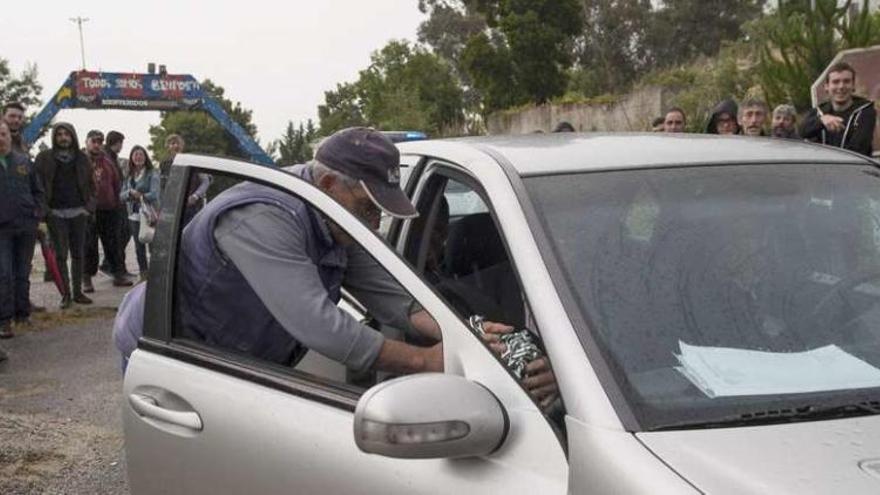 Un benposteño entrega al propietario de Alfer y al abogado la cadena del precinto que les obligó a quitar la Policía Local. // Brais Lorenzo