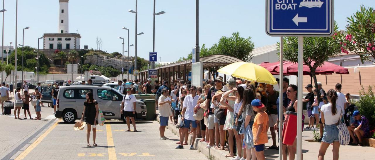 Los cruceristas espera un taxi al sol tras desembarcar. | VICENT MARÍ