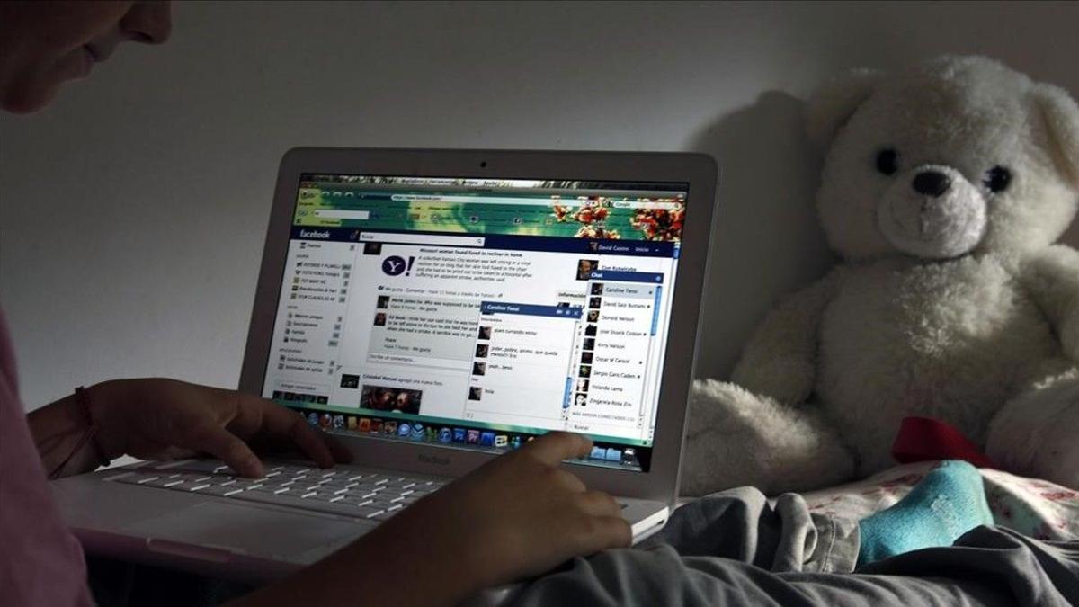 Un niño navega por internet en su habitación.