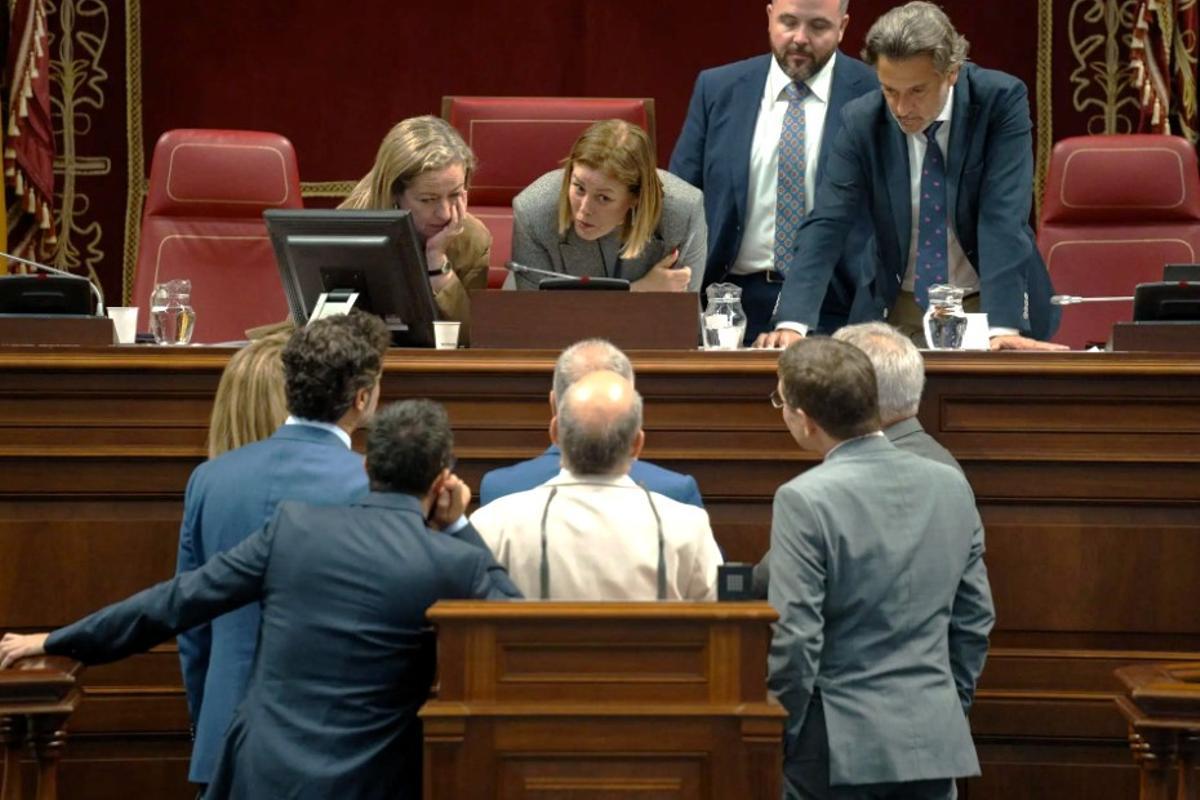 La presidenta del Parlamento de Canarias, Astríd Pérez (c), conversa con los portavoces de los grupos parlamentarios en un pleno.