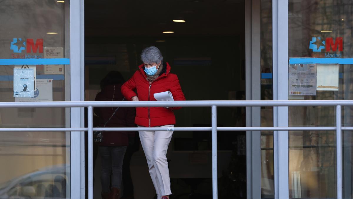 Una mujer con mascarilla sale de un centro de salud