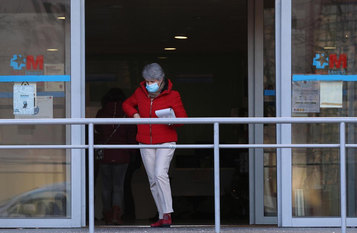 Una mujer con una mascarilla a su salida de un centro de salud.