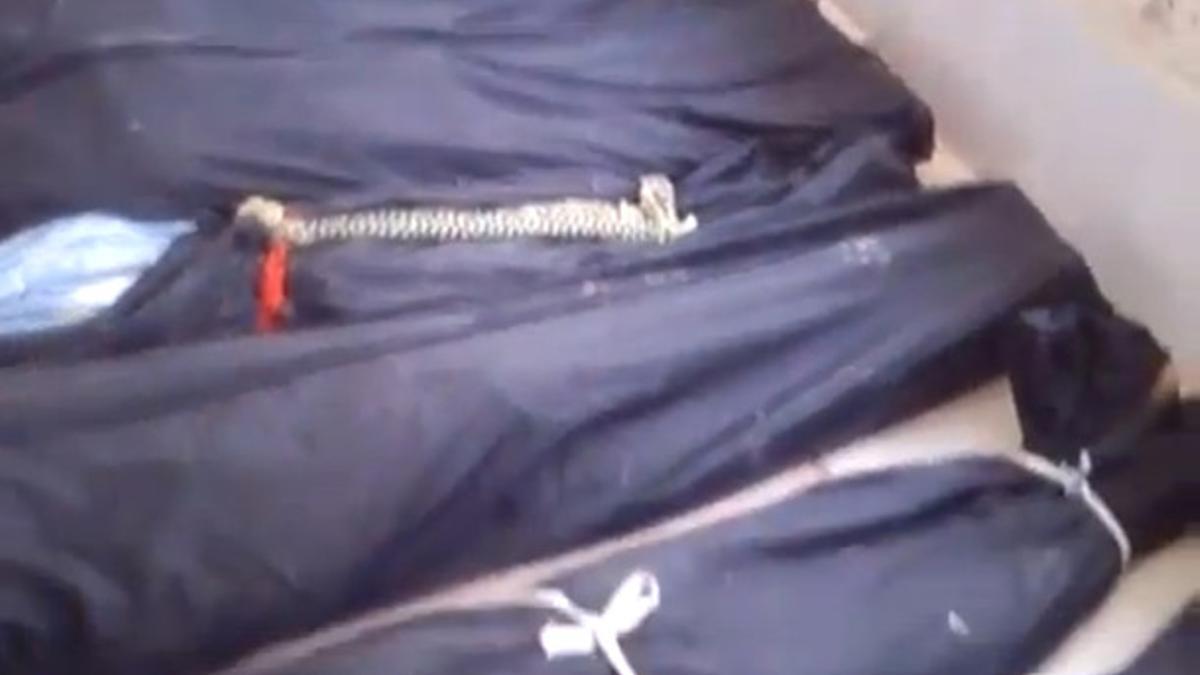 Una imagen de un video que muestra bolsas con cadáveres hallados en Jadidad al Fadel.